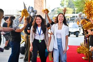 Two new staff members walk through a welcome line during the New Employee Orientation.