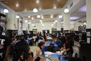 A lively event with students dining and socializing in a hall.