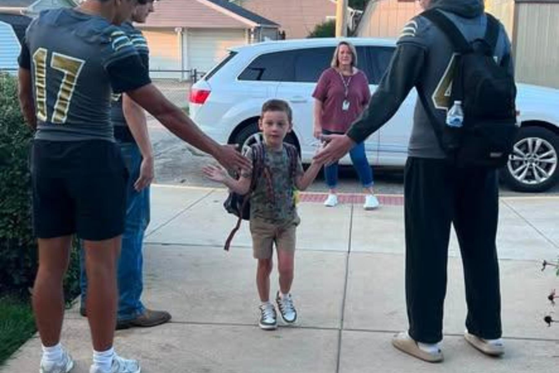 Football players greeting Elmwood students