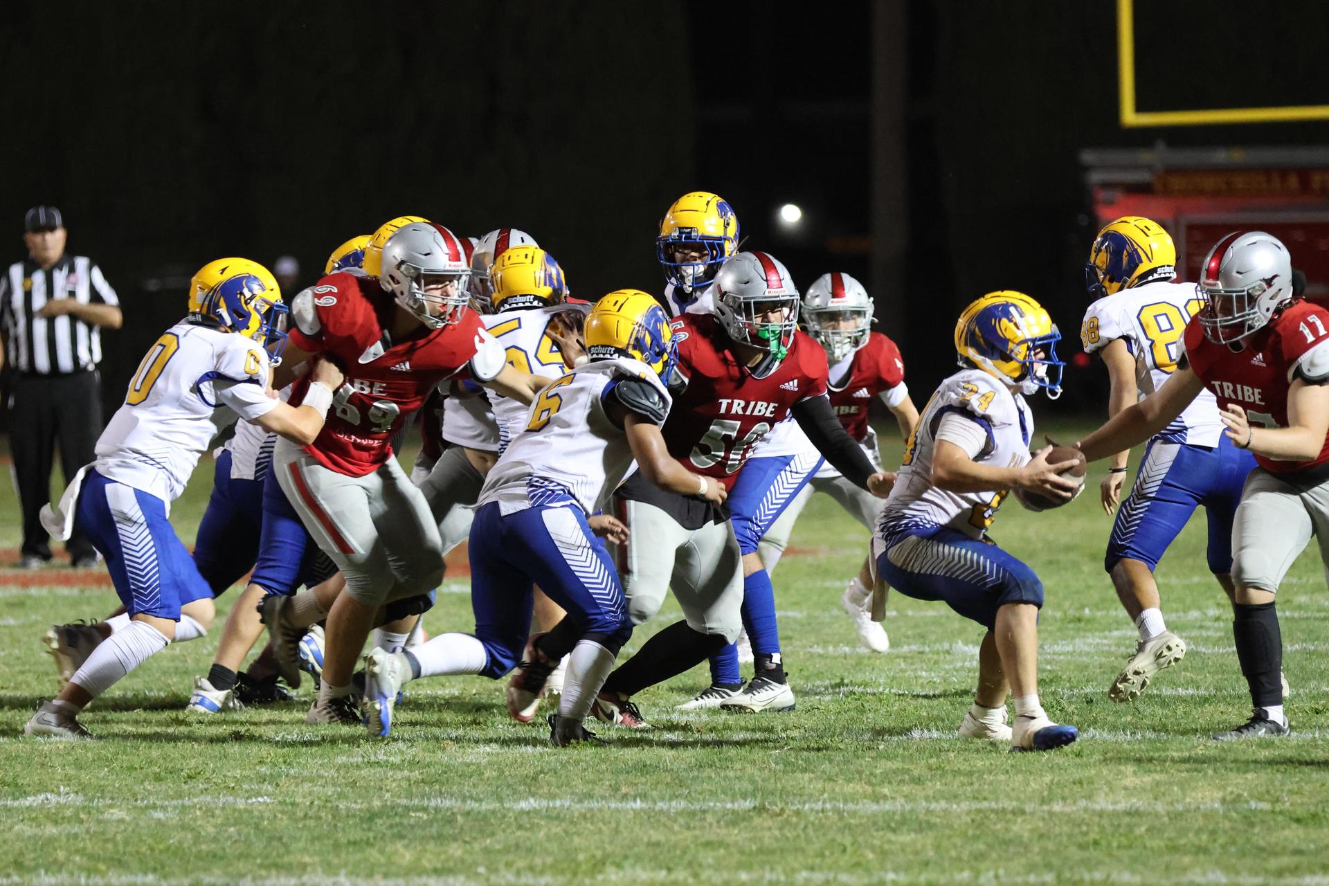 Varsity football players in action against Parlier 97