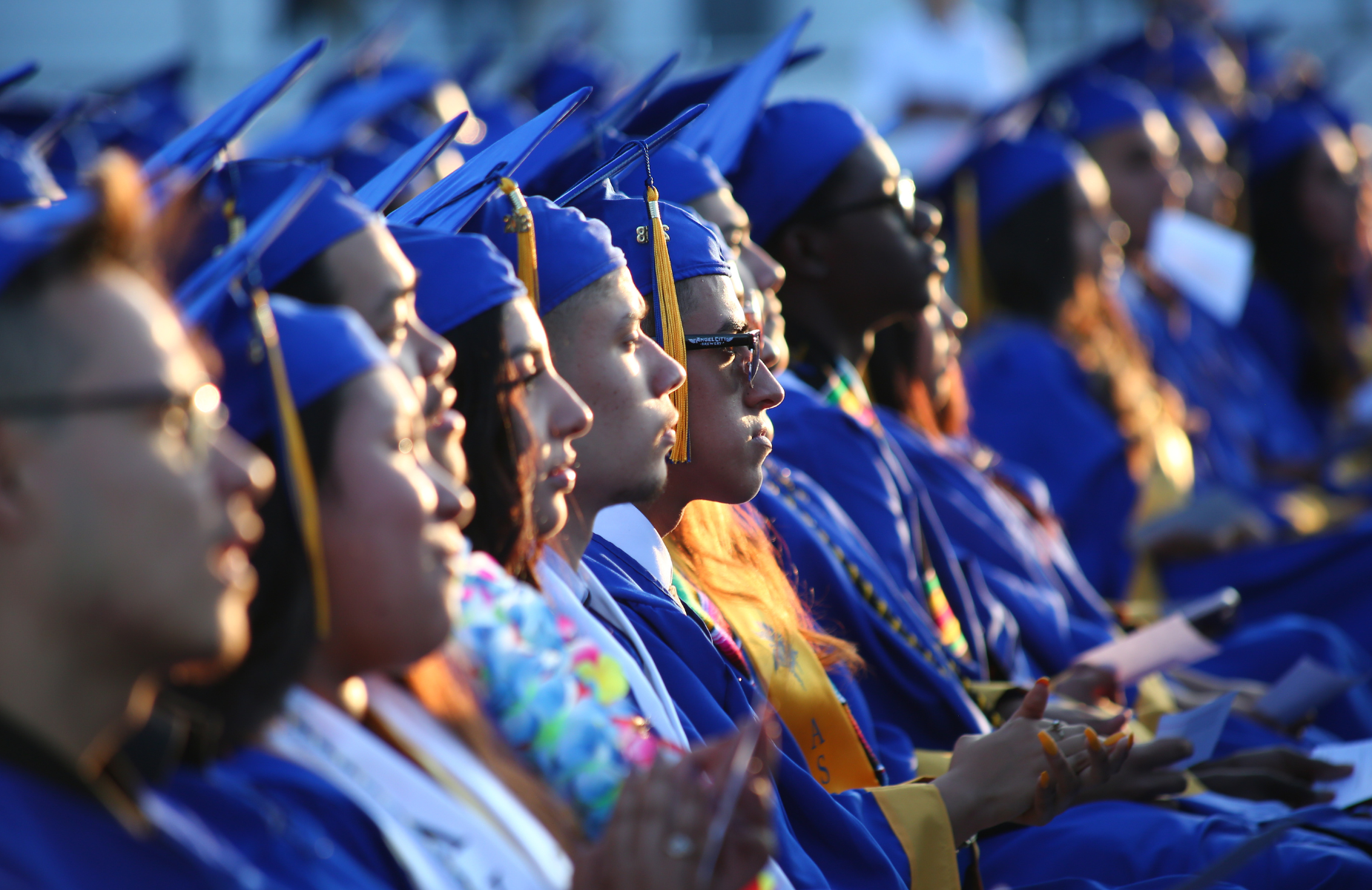 Shuffle banner for district homepage - infographic of students at a graduation ceremony