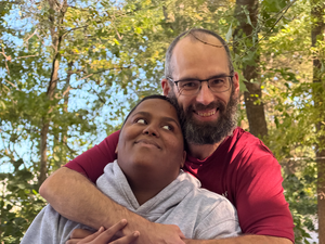 student and staff member hugging and posing for photograph
