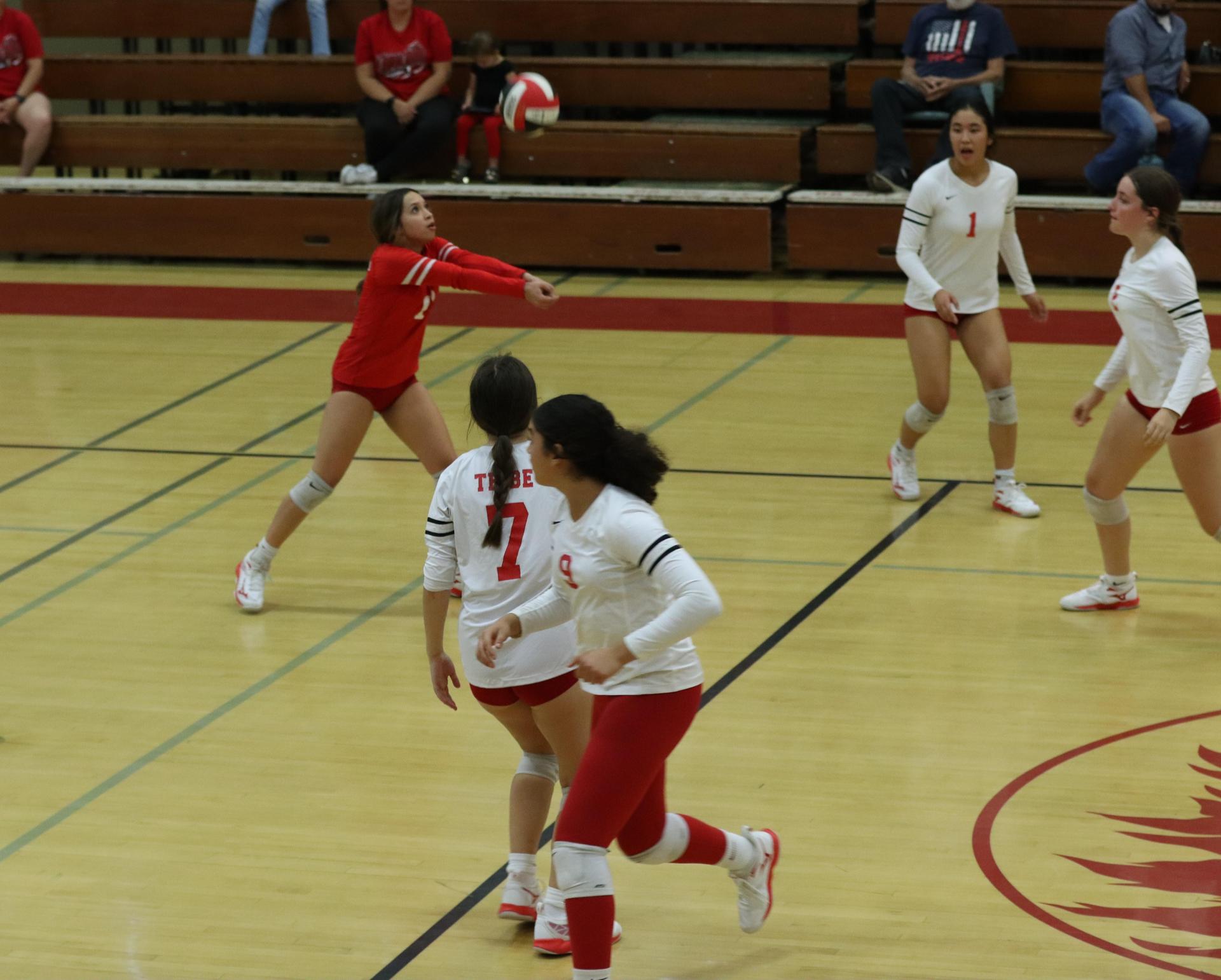 varsity volleyball players in action against liberty