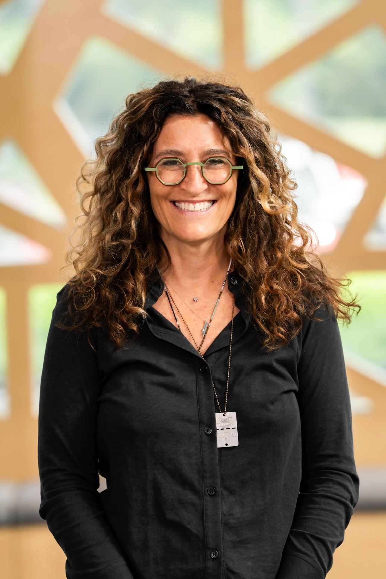 Laura with Curly Hair and glasses smiling