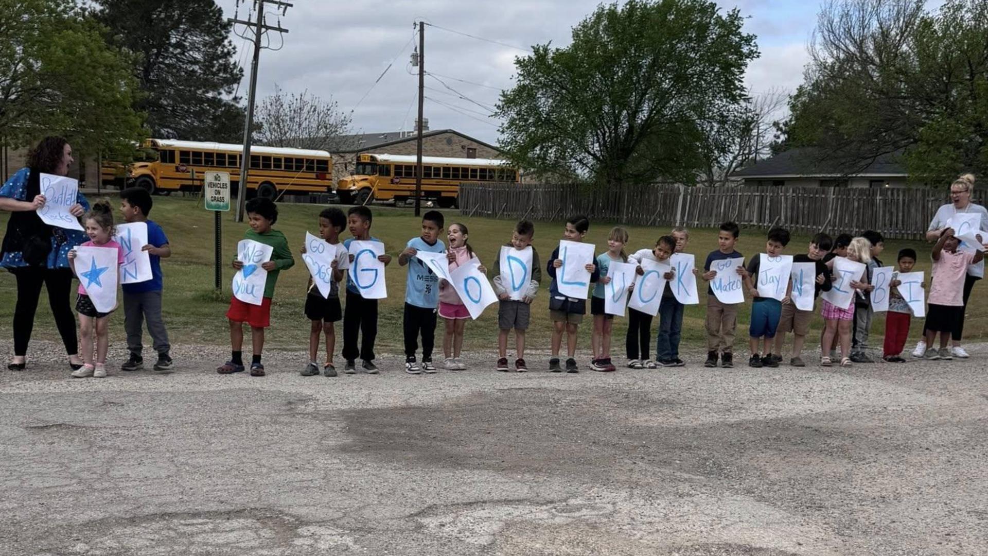 Children holding up colorful letters for a good luck message.