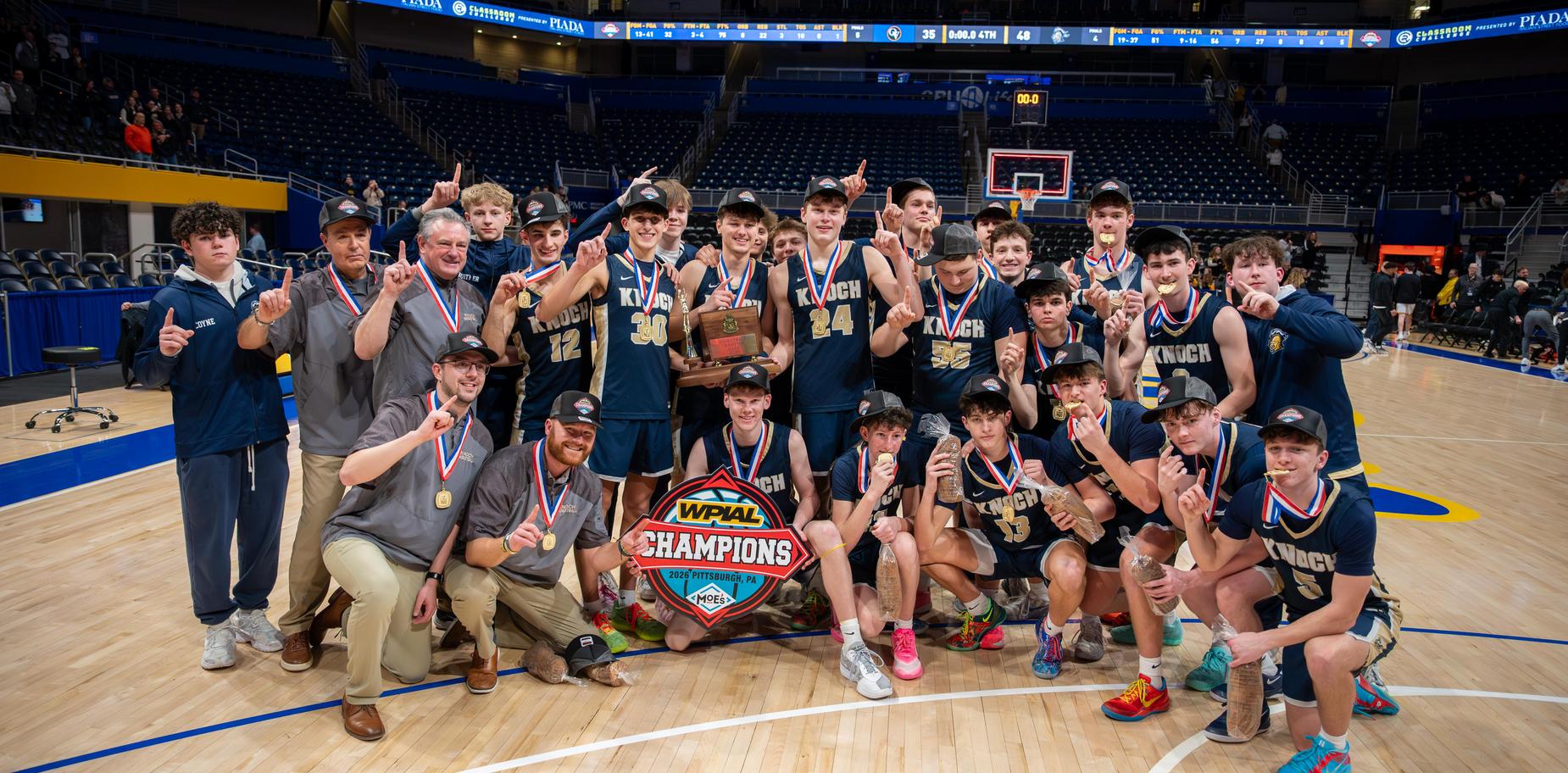 Basketball team celebrating a championship victory on the court.