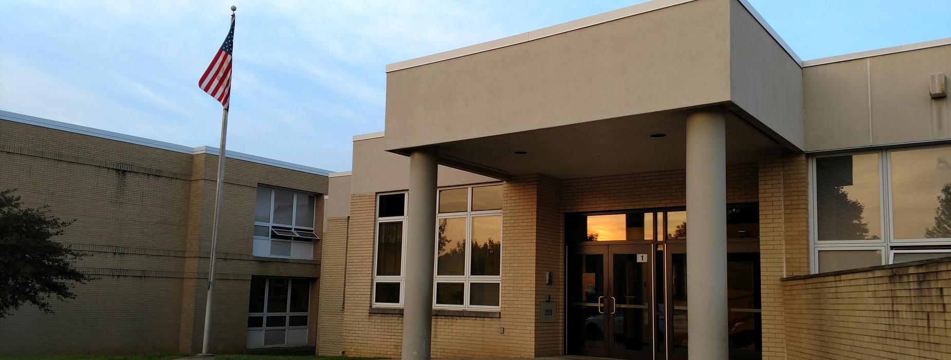 The front of the Elementary Building showing fron t door and the American Flag.
