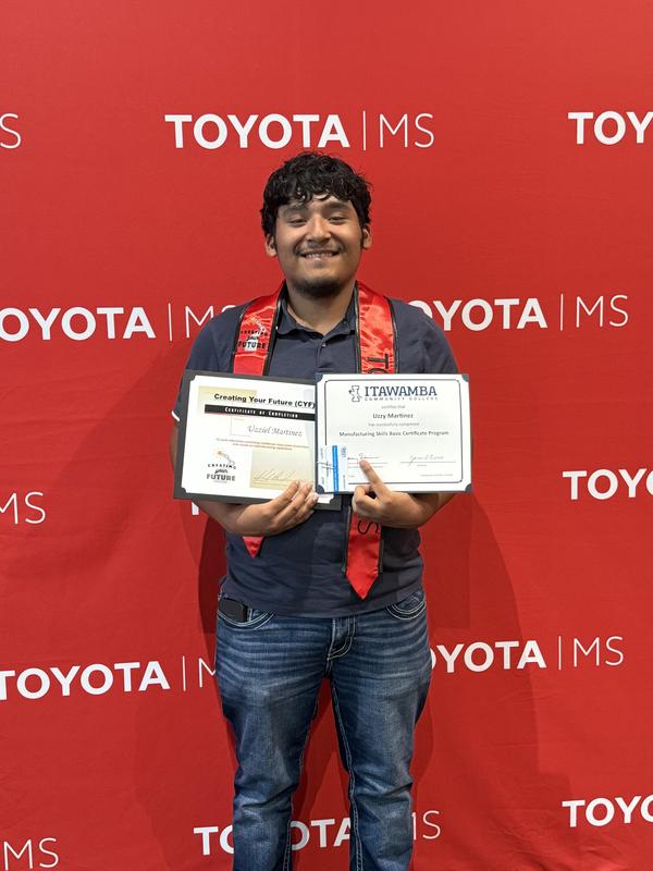 Uzzy Martinez holding his certificates