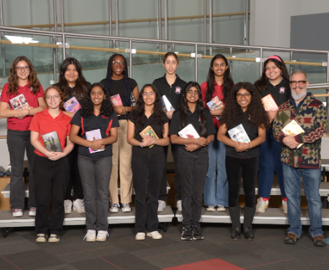 Students stand with books for Book Club
