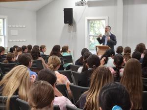 The students listen intently to Rabbi Schusterman