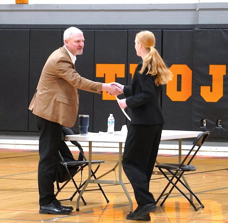 A senior greets her interviewer with a handshake.