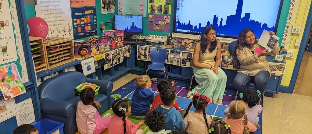 2 female adults reading to 8 students