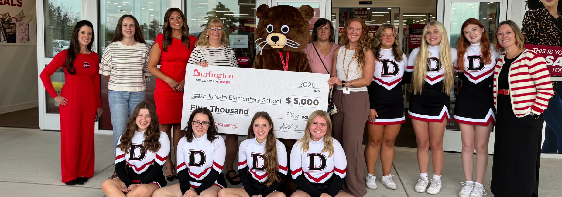 Group of people and a Beaver mascot presenting a big check for $5,000 to a school.