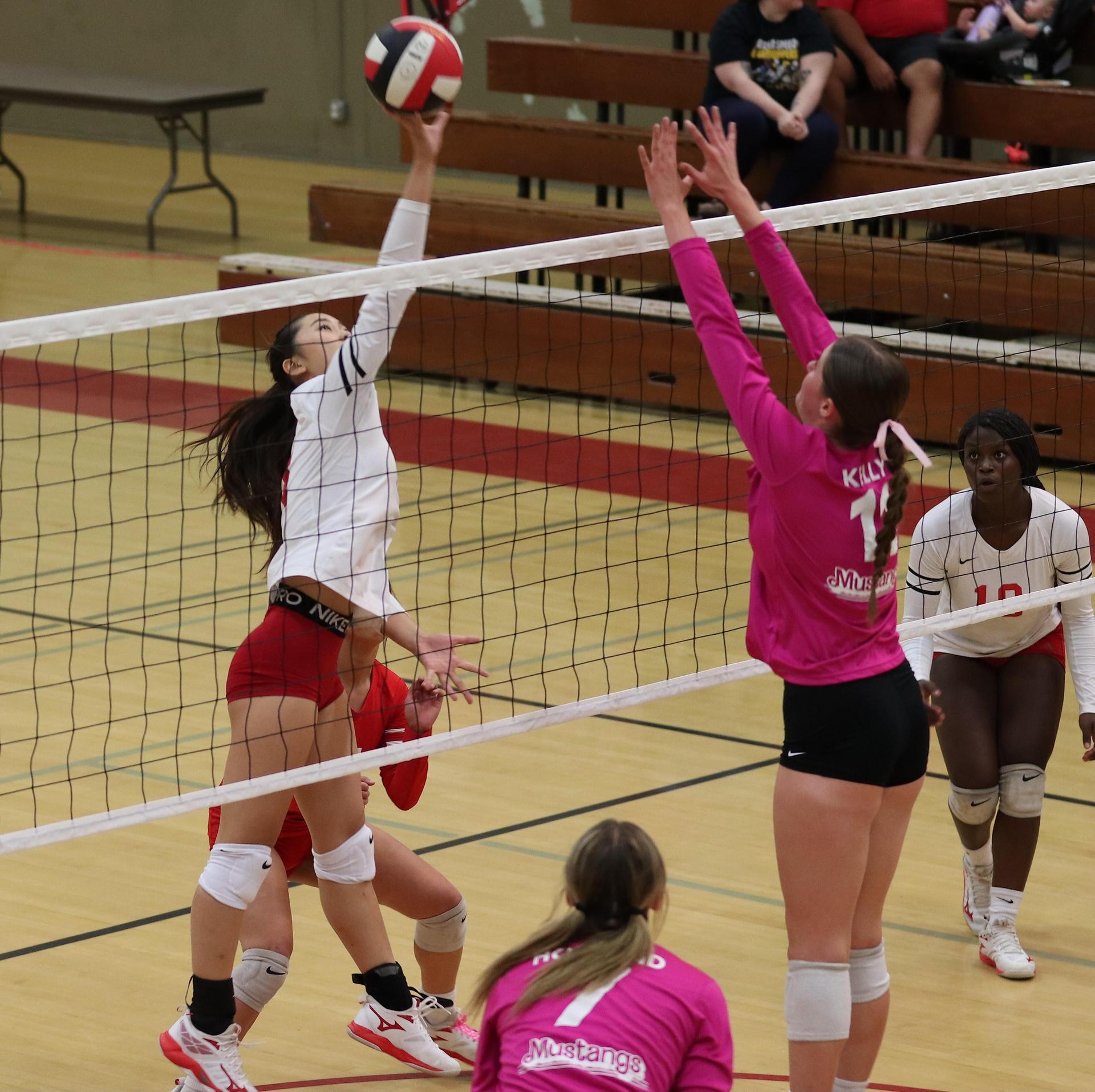 varsity volleyball players in action against Minarets