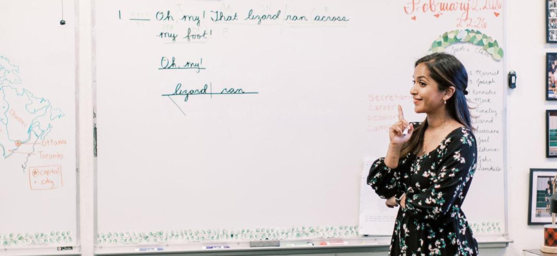 Teacher points to notes on the whiteboard during a lesson