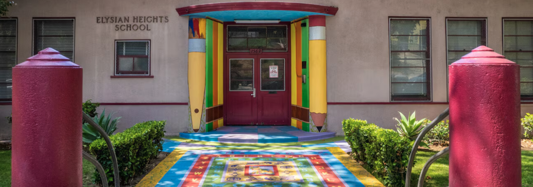 Brightly colored entrance of Elysian Heights School with decorative pathways and plants.