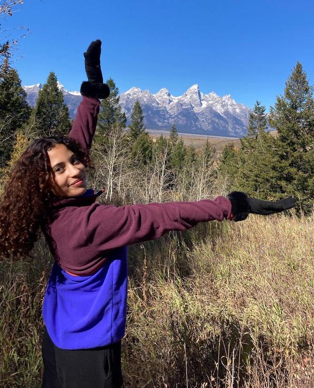 Student framing mountains with her arms.