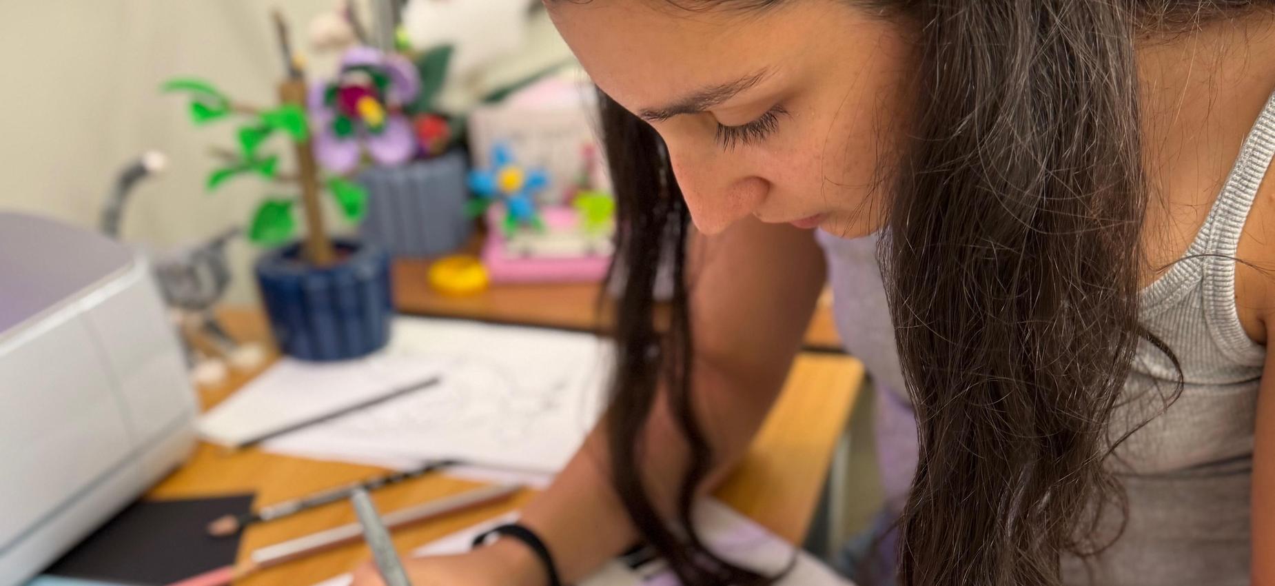 Student working at a poster on a desk