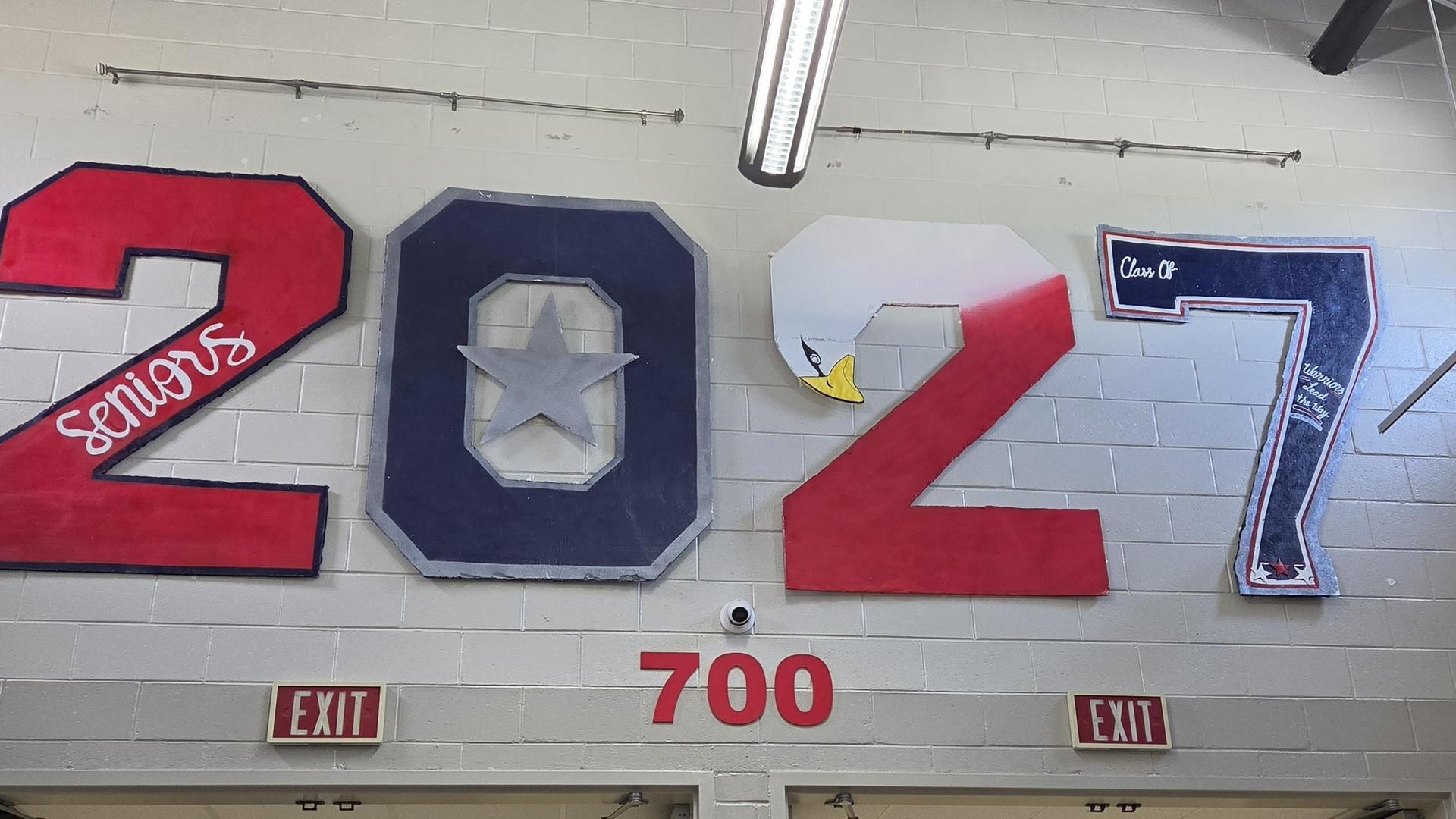 Wall display featuring painted numbers and text, celebrating Class of 2027.