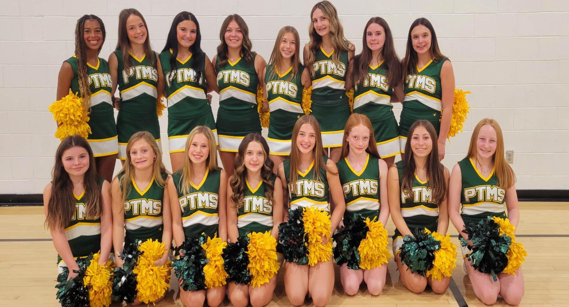 Cheerleading team posing together with pom-poms in school uniforms.