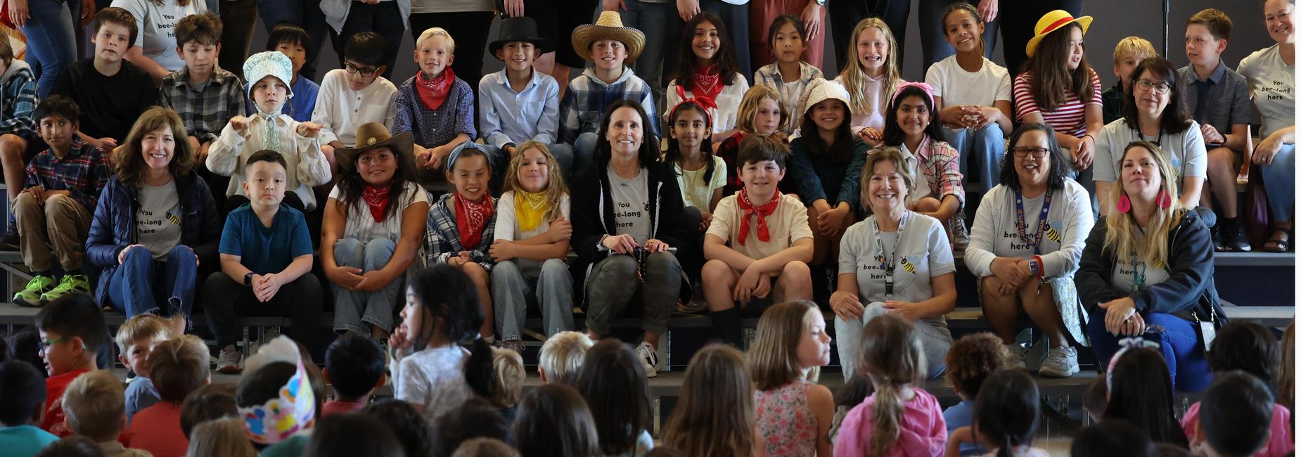 large group of smiling students sitting on stairs
