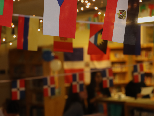 Colorful flags hang in a decorated room with lights and a festive atmosphere.