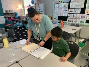 Teacher Nicole Taha reviews spelling words with Ram Aseron