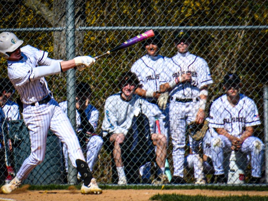 Baseball player swinging a bat at the plate.