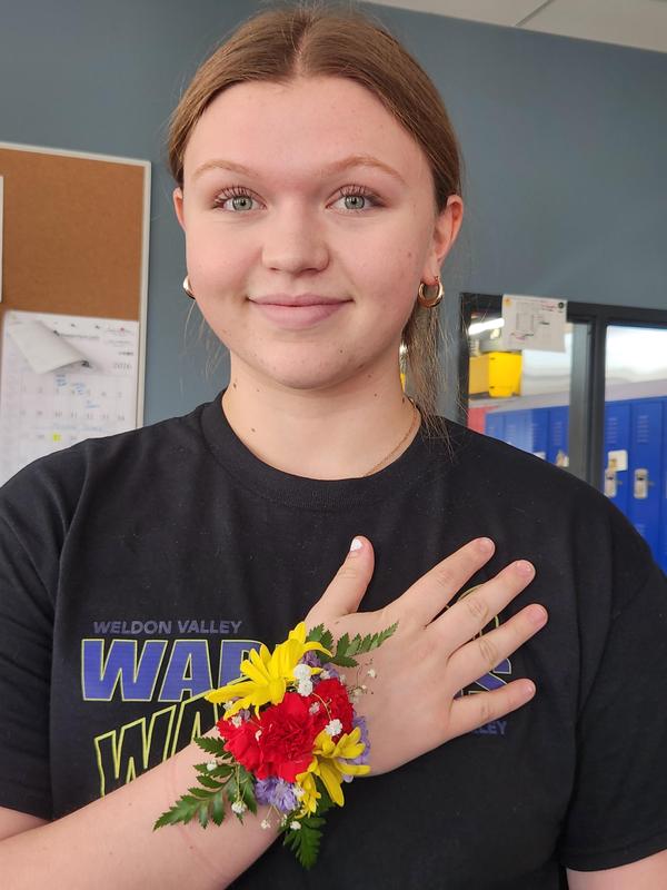 Haylee Nelson holding her hand showing off the corsage she made.