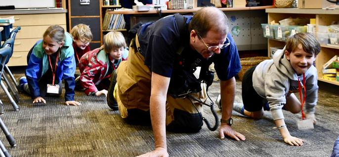 Firefighter demonstrating crawling below smoke