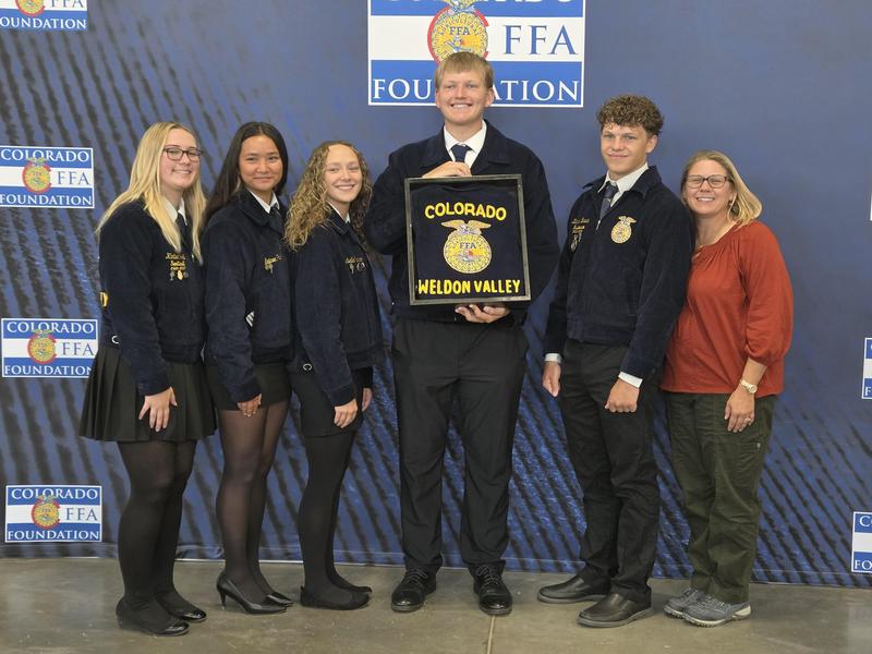 FFA members and sponsor at Blue Jacket Event holding donated FFA jacket