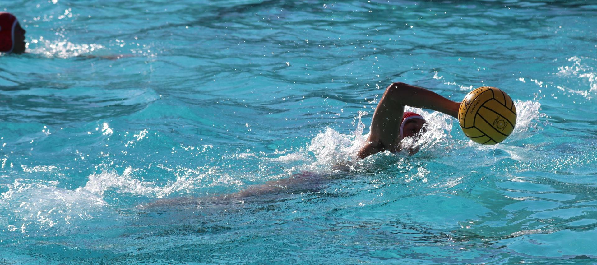 boys water polo players in action against hoover