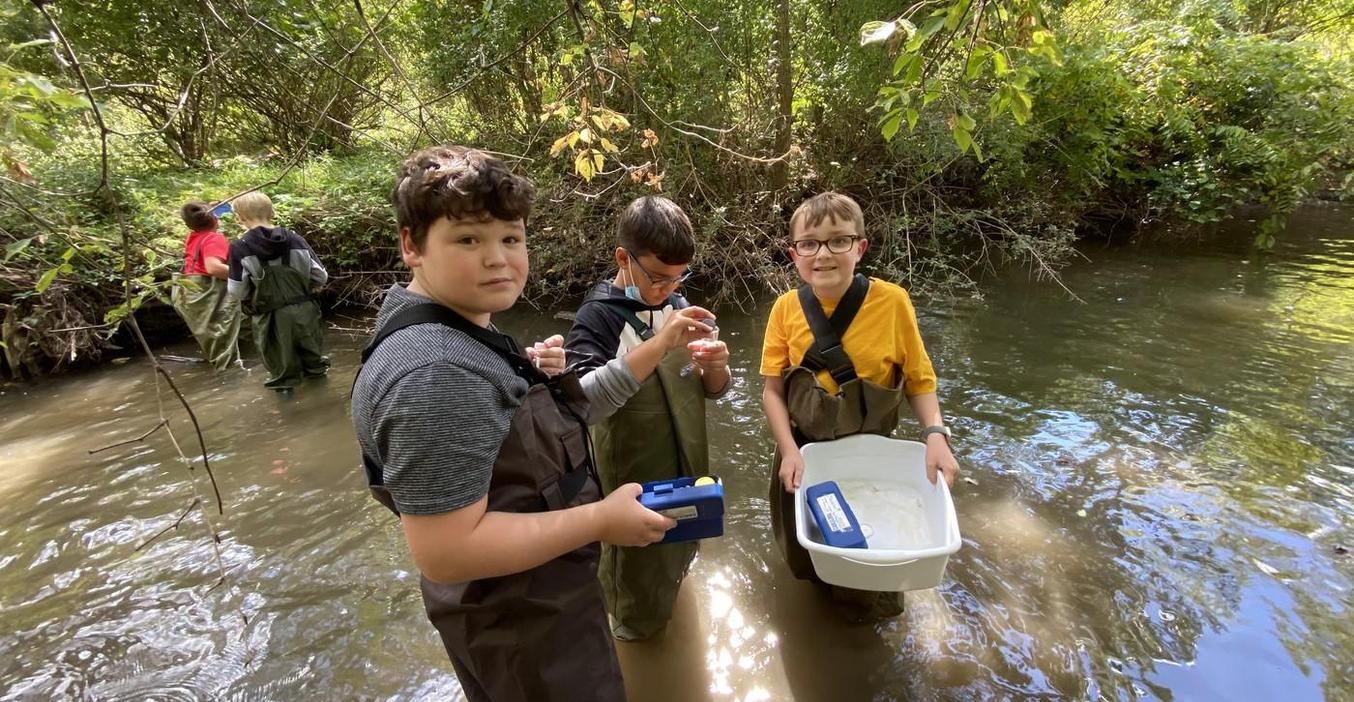 Middle school science students study insects in the nearby creek.