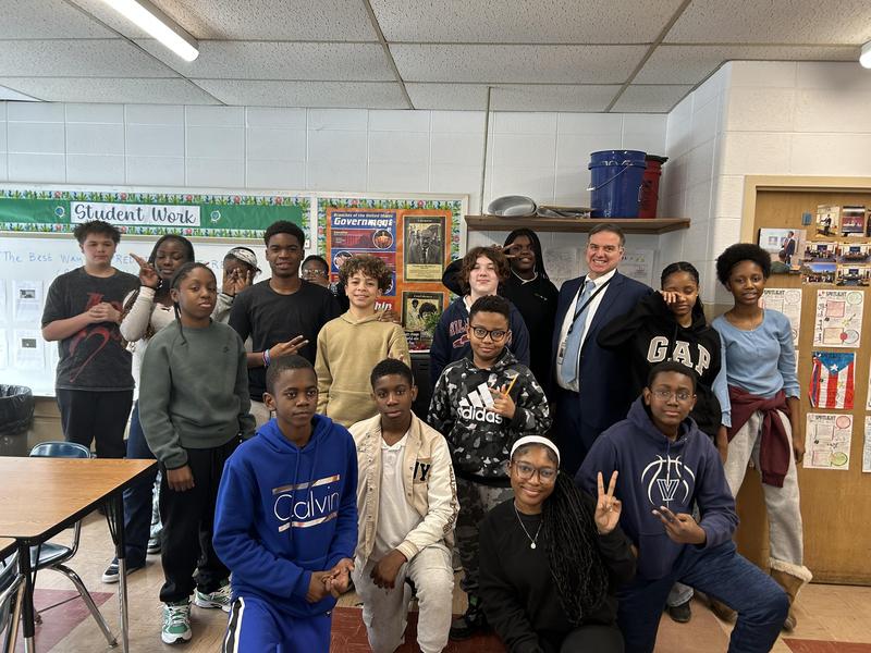 Students posing with Judge Vitale inside of a classroom.