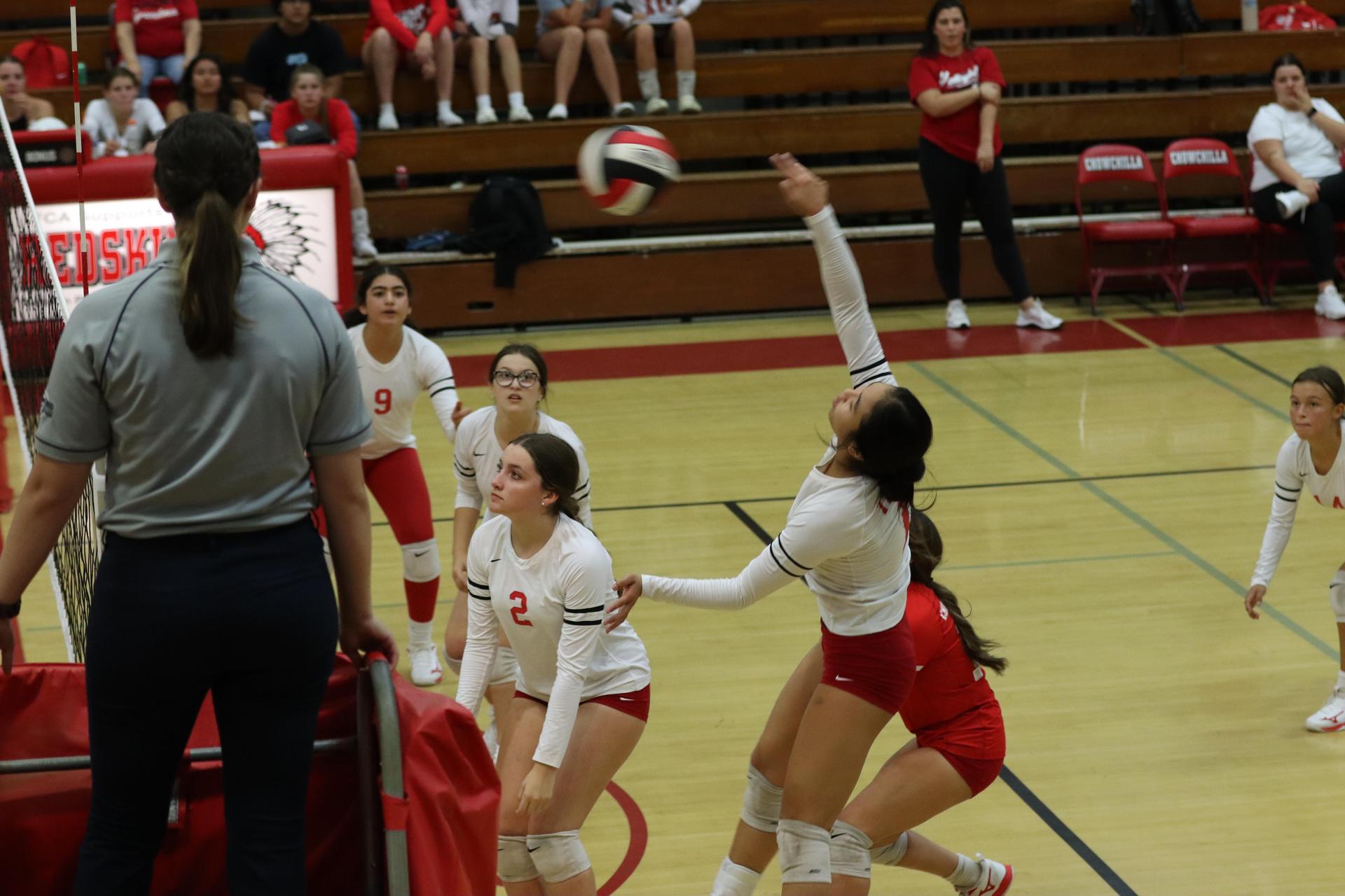 varsity volleyball players in action against liberty