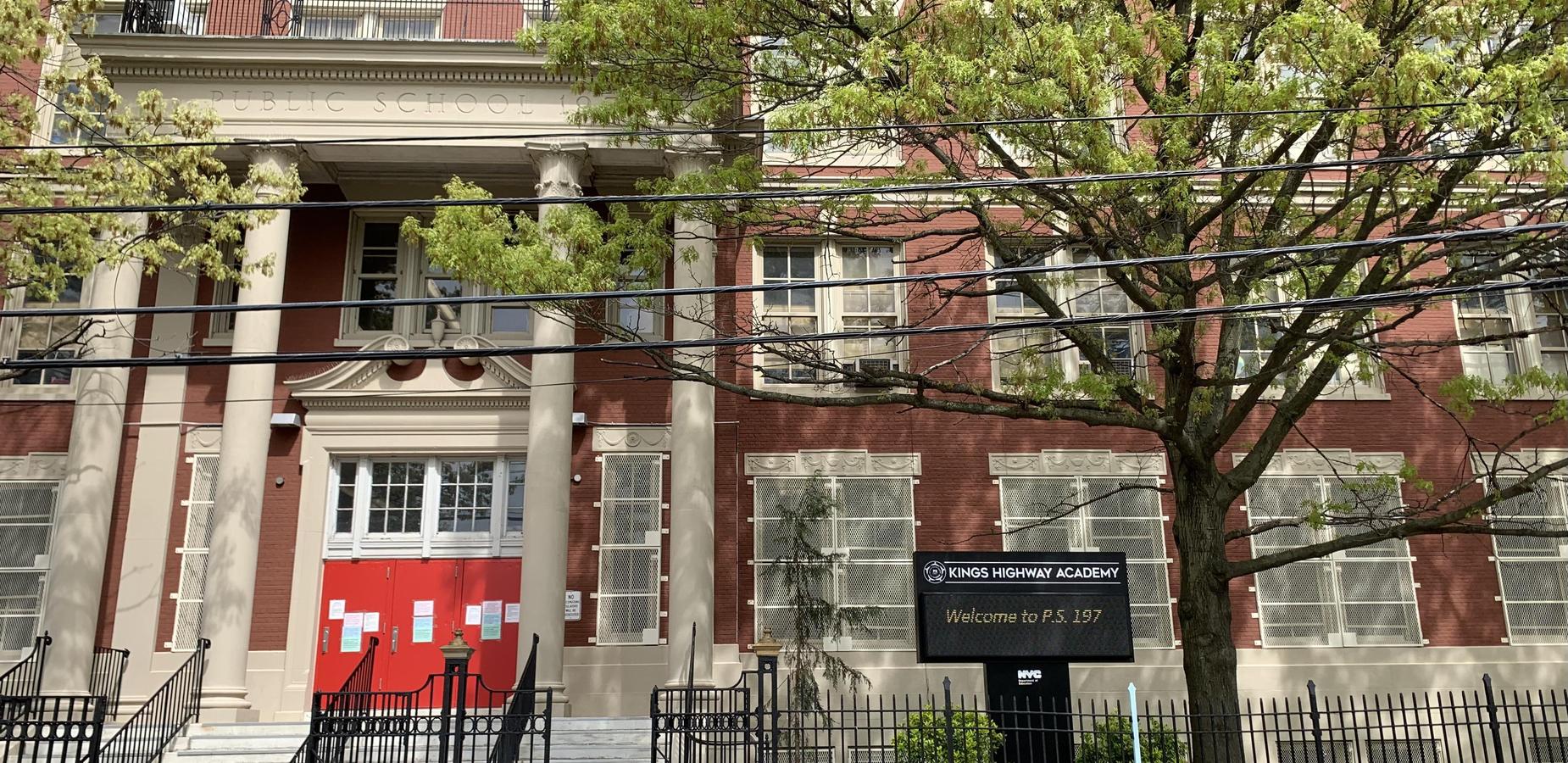 Red brick public school building with a prominent sign for Kings Highway Academy.
