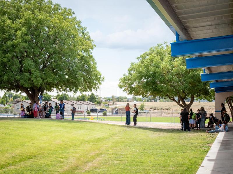 teachers and students talking after school outside on campus