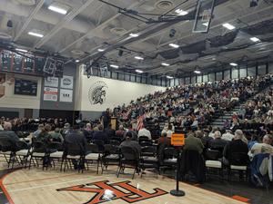 The gymnasium is filled with students, staff and community members.