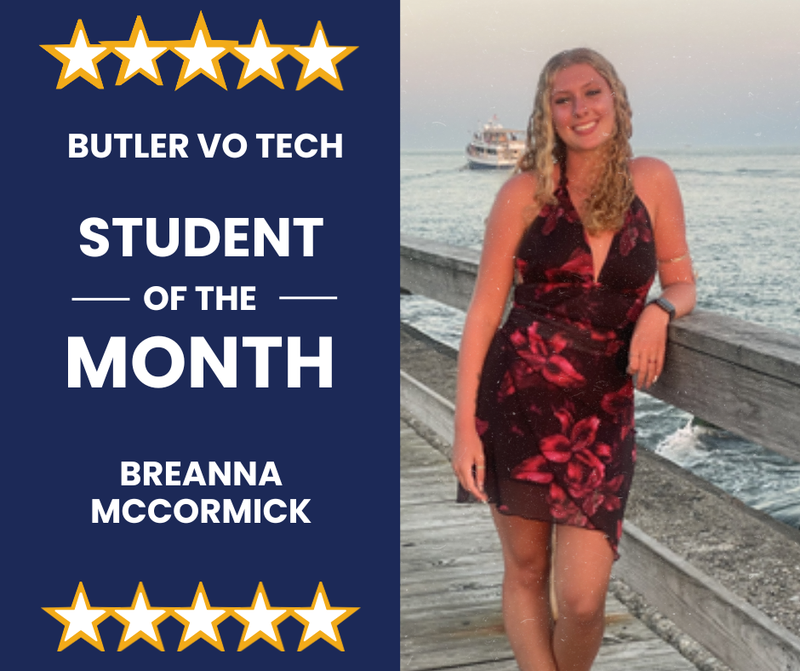 blond girl on a pier leaning on post next to water