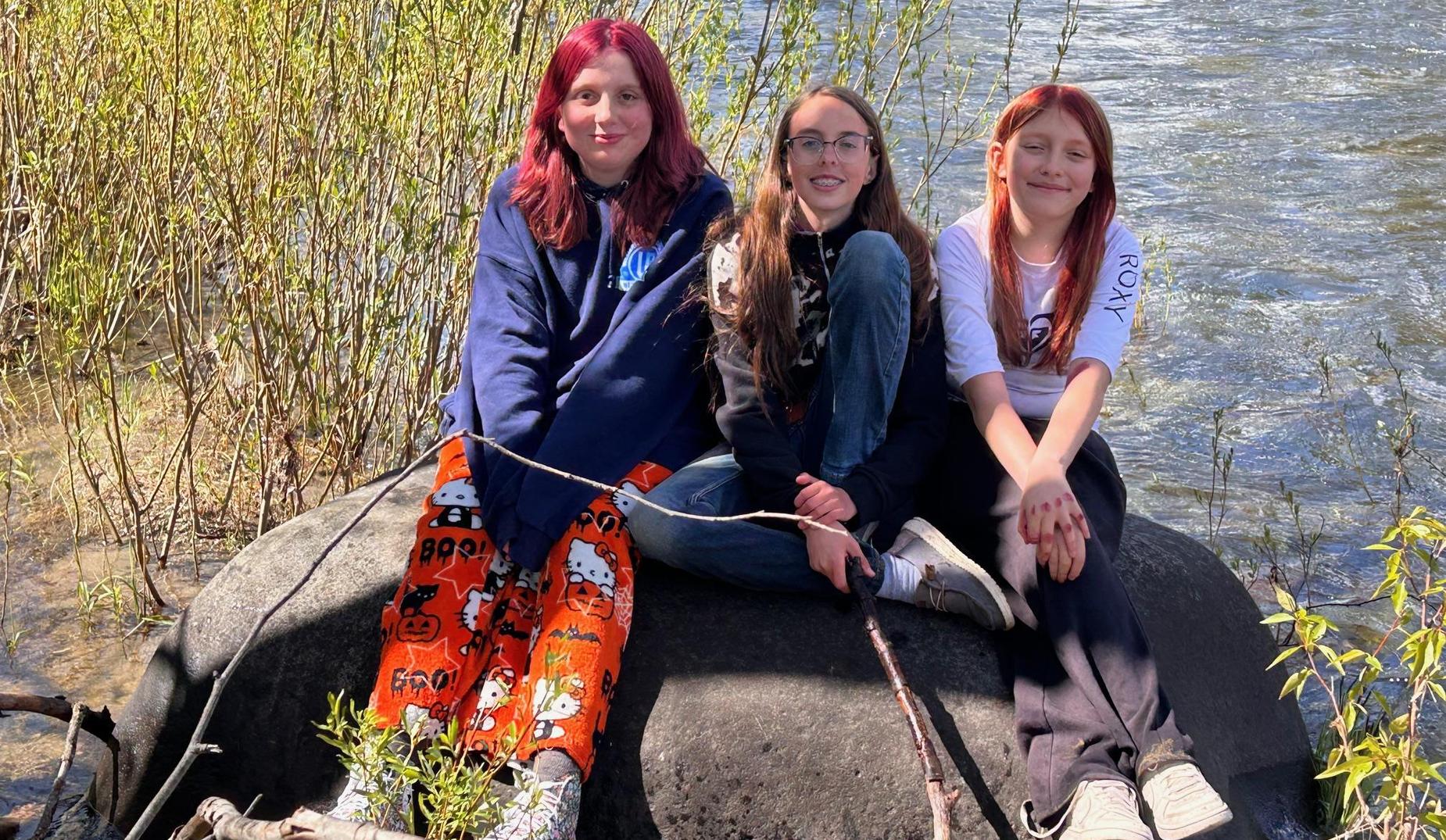 Students on a rock in a stream