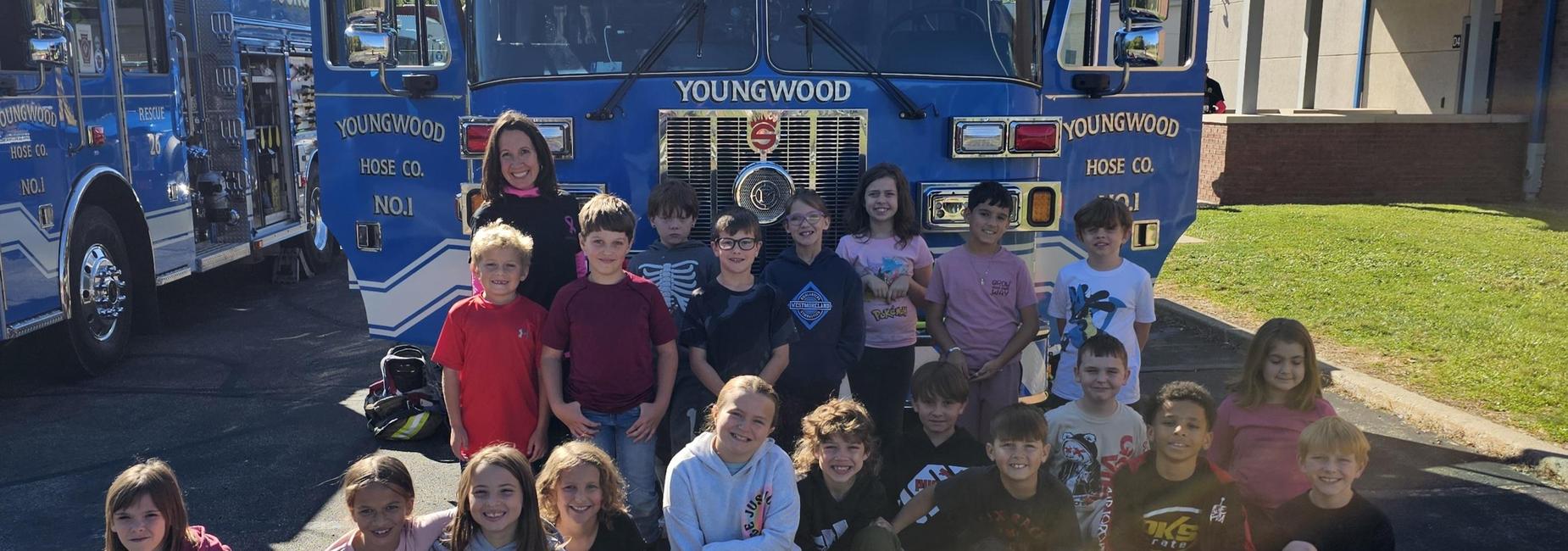 students posing in front of a fire truck