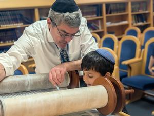 Boy looking at torah