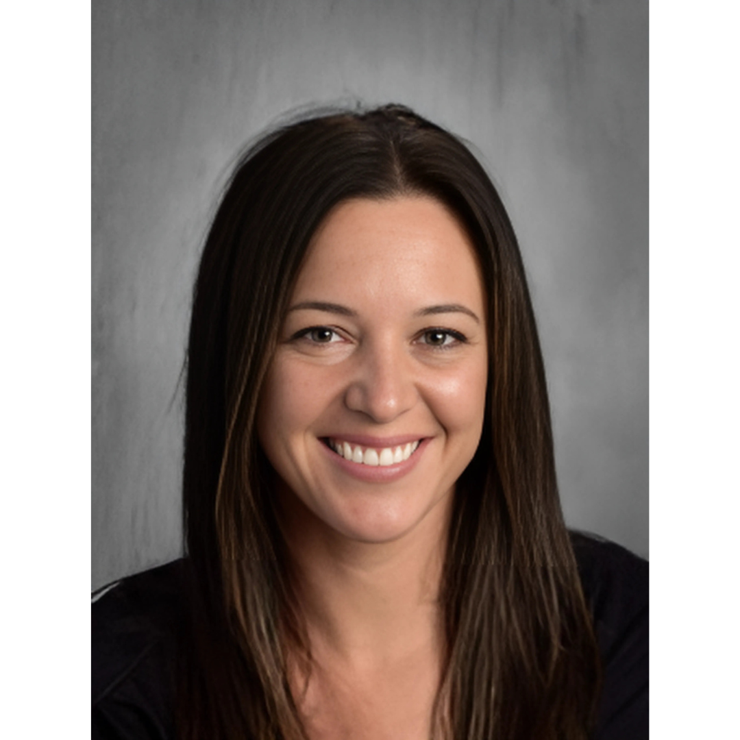 A person with long brown hair smiling at the camera