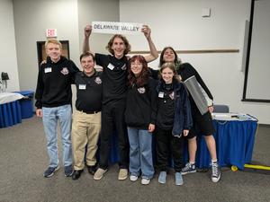 a group of students stand with a sign that says delaware valley