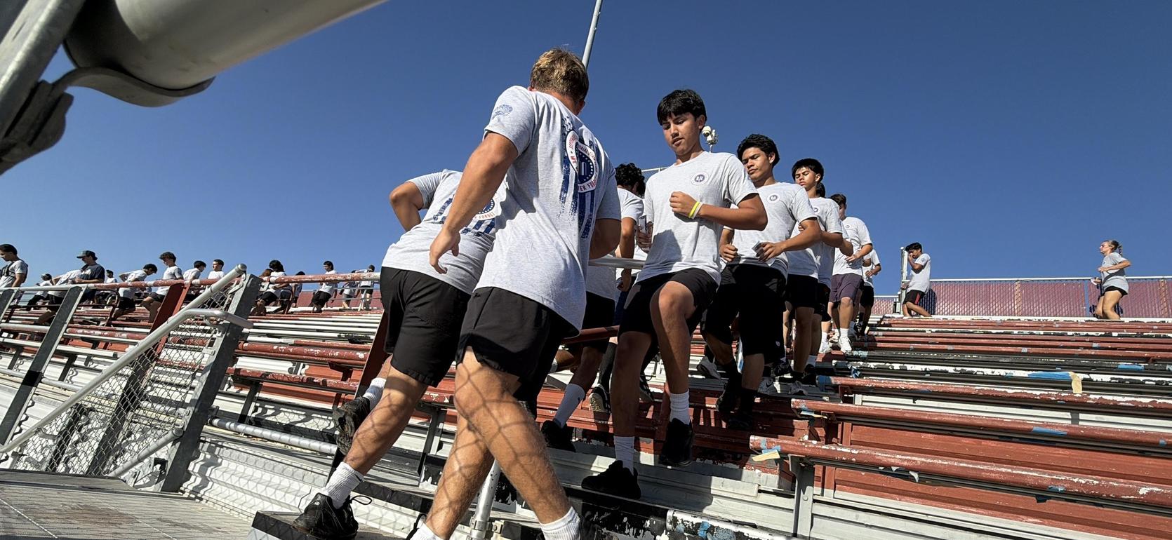 Group of young athletes climbing stadium steps during a training session.