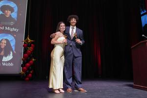 2 seniors, a boy and a girl, on stage with Oscar trophies
