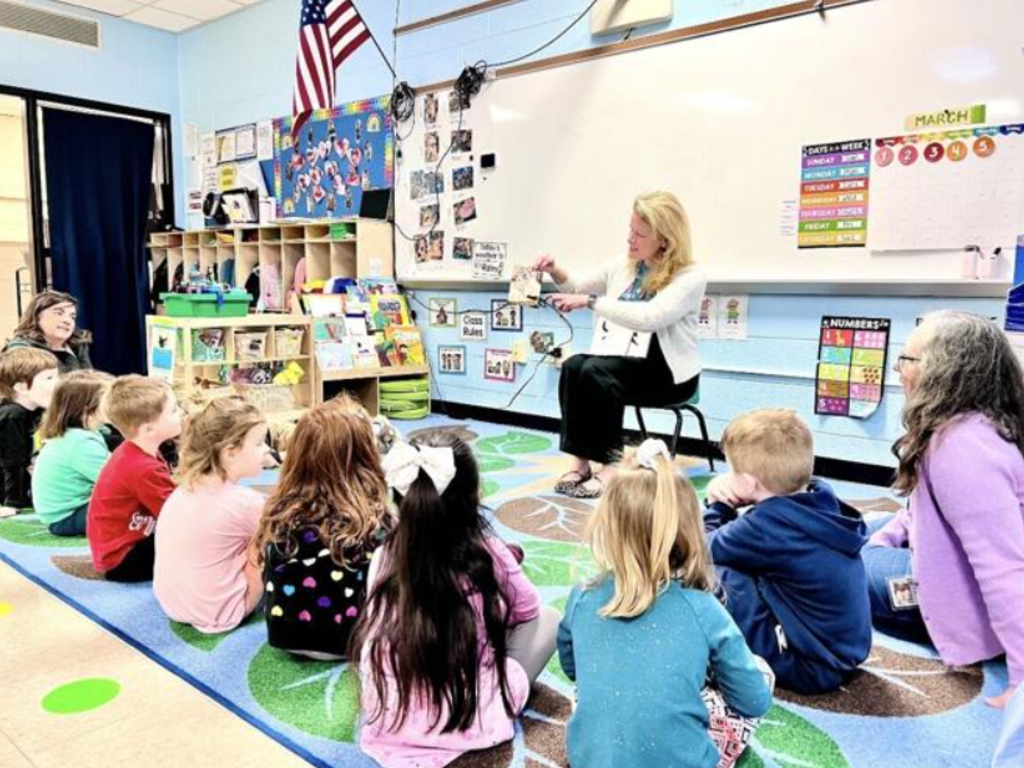 Dr. O'Connell reading to a group of pre-k children in a classroom.