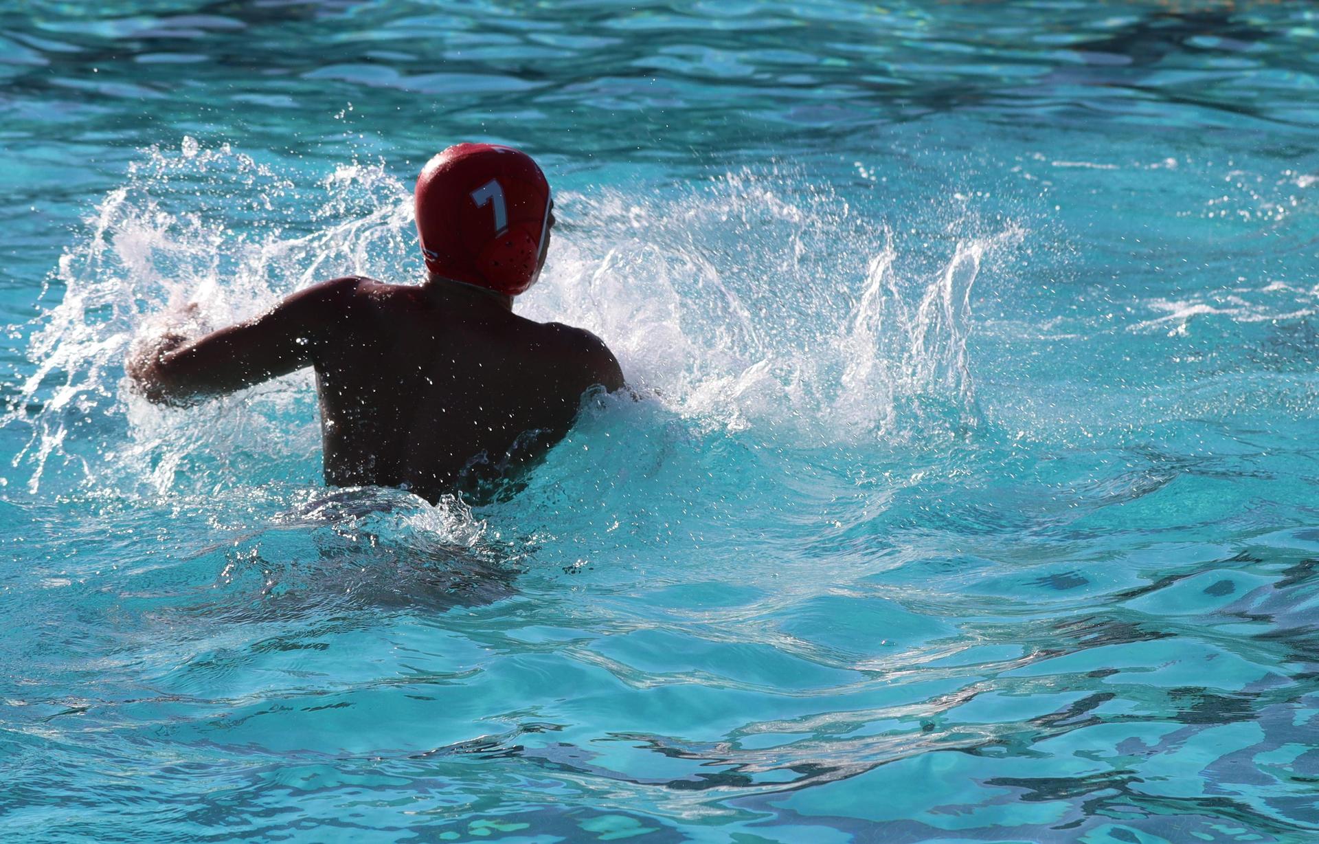 boys water polo players in action against hoover