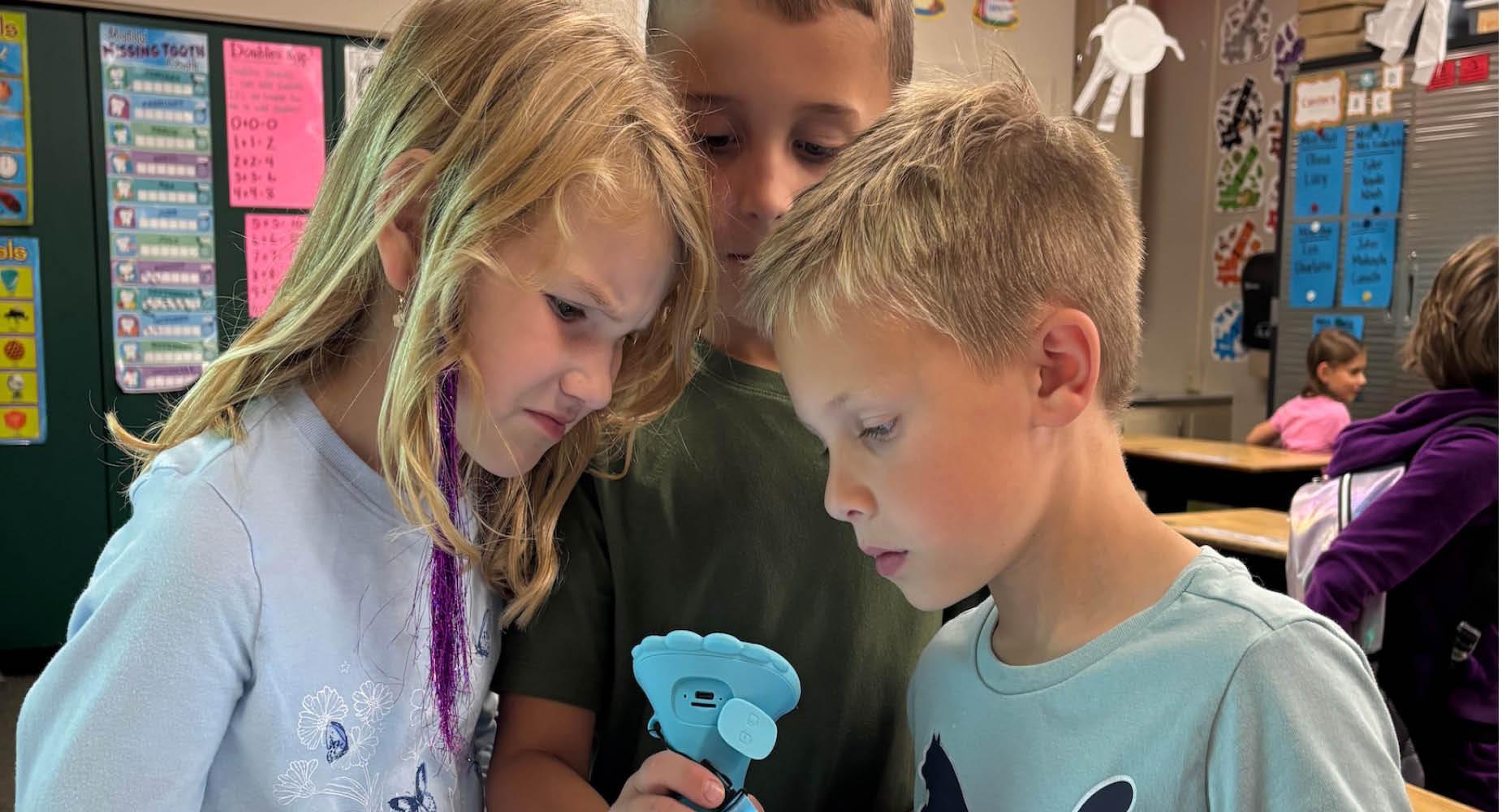 Zoe Miller, Waylon Jack, and Liam Driskill observe an image through the new microscope at Level Green Elementary