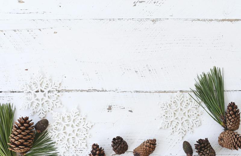 White wooden wall with pinecones and white snowflake decor